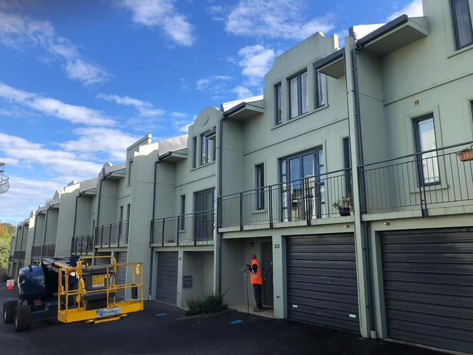 Townhouse development exterior repaint with elevated access equipment on site